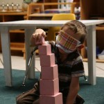 A blindfolded boy exploring the sense of touch and arranging blocks according to their size