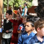 Boys and girls standing in a que holding their national flags