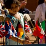 A little girl student looking at international flags